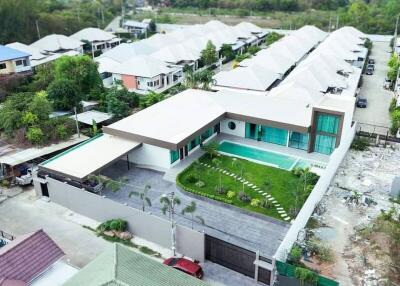 Aerial view of a modern house with a pool and lawn