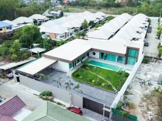 Aerial view of a modern house with a pool and lawn