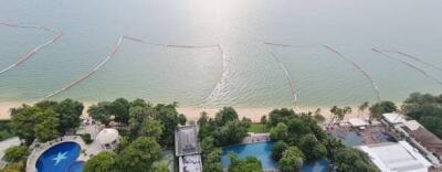 Aerial view of beachfront area with swimming pools and greenery