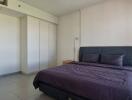 Bedroom with gray bedspread and ample lighting