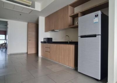 Modern kitchen area with wooden cabinetry and sleek appliances