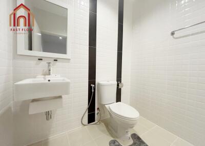 Modern white bathroom with sink, toilet, and mirror