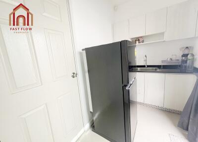 Modern kitchen with black refrigerator and white cabinetry