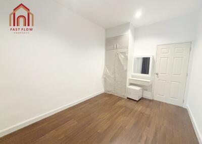 Spacious empty bedroom with hardwood floors and built-in wardrobe