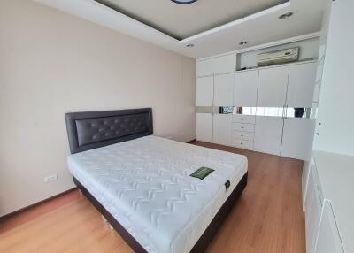 A modern bedroom with a large bed and ample storage space