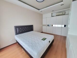 A modern bedroom with a large bed and ample storage space