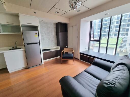 Modern living room with kitchen area and large windows