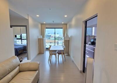 Main living area with dining table and view of balcony