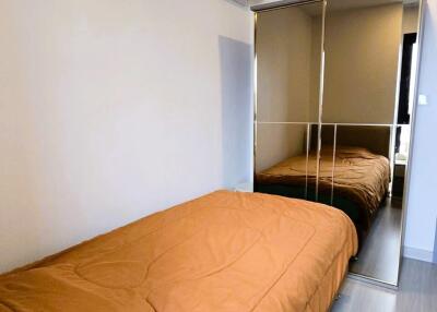 Small bedroom with a bed, mirrored wardrobe, and air conditioning unit.