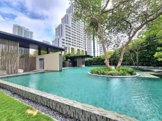 Outdoor swimming pool area with modern buildings in the background