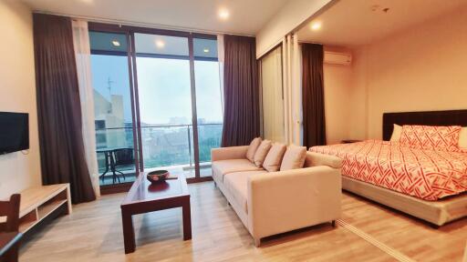 Spacious studio apartment with large windows and modern furnishings