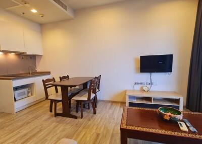 Living area with dining table and wall-mounted TV