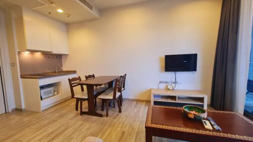 Living area with dining table and wall-mounted TV