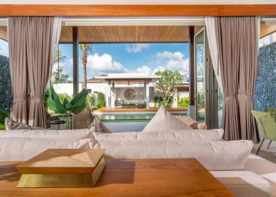 Living room with open view of a pool and outdoor seating area