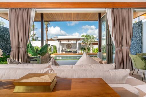 Living room with open view of a pool and outdoor seating area