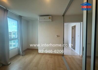 Modern bedroom with wooden flooring and large window