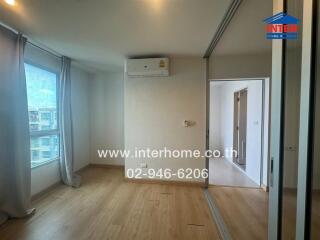 Modern bedroom with wooden flooring and large window