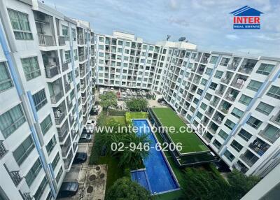 View of residential buildings with a swimming pool and green space