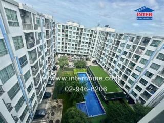 View of residential buildings with a swimming pool and green space