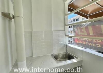 Small corner kitchen with a sink, countertop, and window