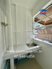 Small corner kitchen with a sink, countertop, and window