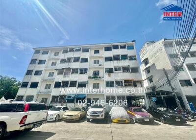 Exterior view of an apartment building with parked cars