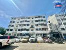 Exterior view of an apartment building with parked cars