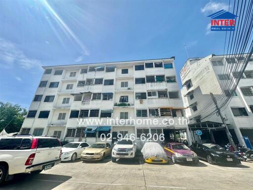 Exterior view of an apartment building with parked cars