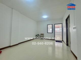 Spacious living room with white walls and tiled floor