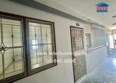 Exterior view of a building hallway with windows and a door