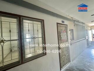 Exterior view of a building hallway with windows and a door