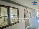 Exterior view of a building hallway with windows and a door