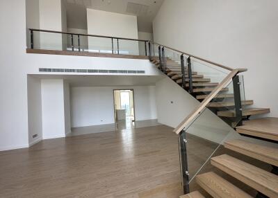 Spacious living area with modern staircase and wooden flooring