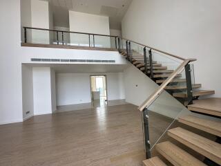 Spacious living area with modern staircase and wooden flooring