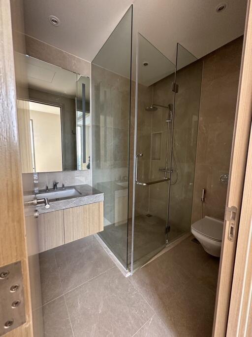 Modern bathroom with glass shower enclosure and vanity mirror