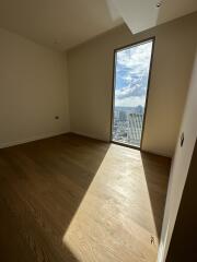 Empty room with wooden flooring and large window