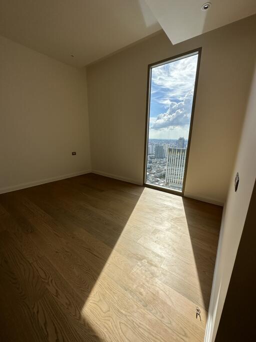 Empty room with wooden flooring and large window