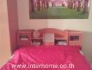 Bedroom with pink bedspread and wall poster