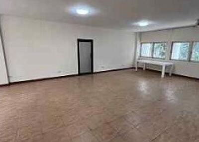 Spacious and empty living room with tiled flooring and large windows