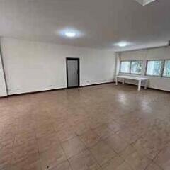 Spacious and empty living room with tiled flooring and large windows