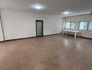 Spacious and empty living room with tiled flooring and large windows