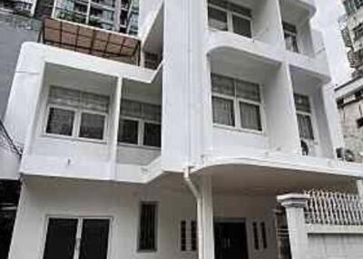 Exterior view of a multi-story residential building with a gated entrance