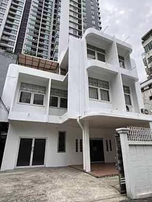 Exterior view of a multi-story residential building with a gated entrance