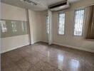 Empty room with windows, air conditioner and lighting fixtures