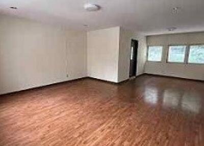 Spacious living room with wooden flooring and large windows