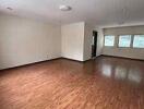 Spacious living room with wooden flooring and large windows