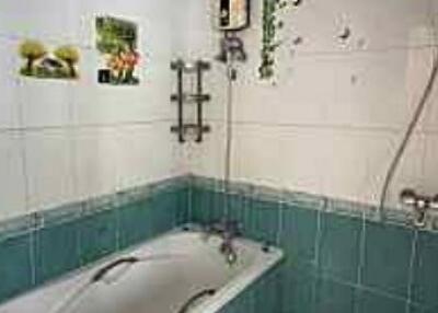 Bathroom with tiled walls, bathtub, and shower