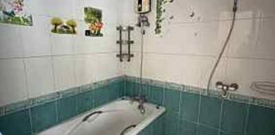 Bathroom with tiled walls, bathtub, and shower