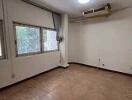 vacant living room with large windows and air conditioning unit