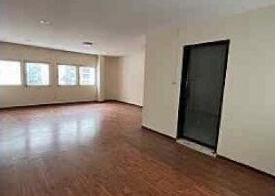 Spacious living room with wooden floors and large windows